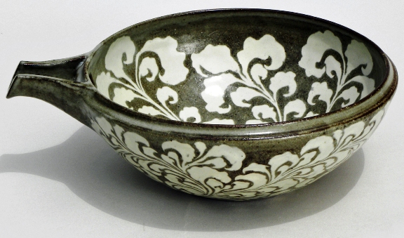 “Bowl with Spout” wheel thrown, iron rich stoneware clay. Japanese Arabesque design carved free hand, inlayed with white slip, 11 x 9 x 4 in, clear glaze, fired to cone 9 reduction, 2010
