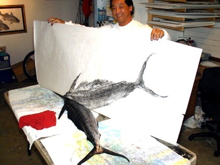 The artist Naoki, of Hawaii, is shown taking a gyotaku print from a swordfish.